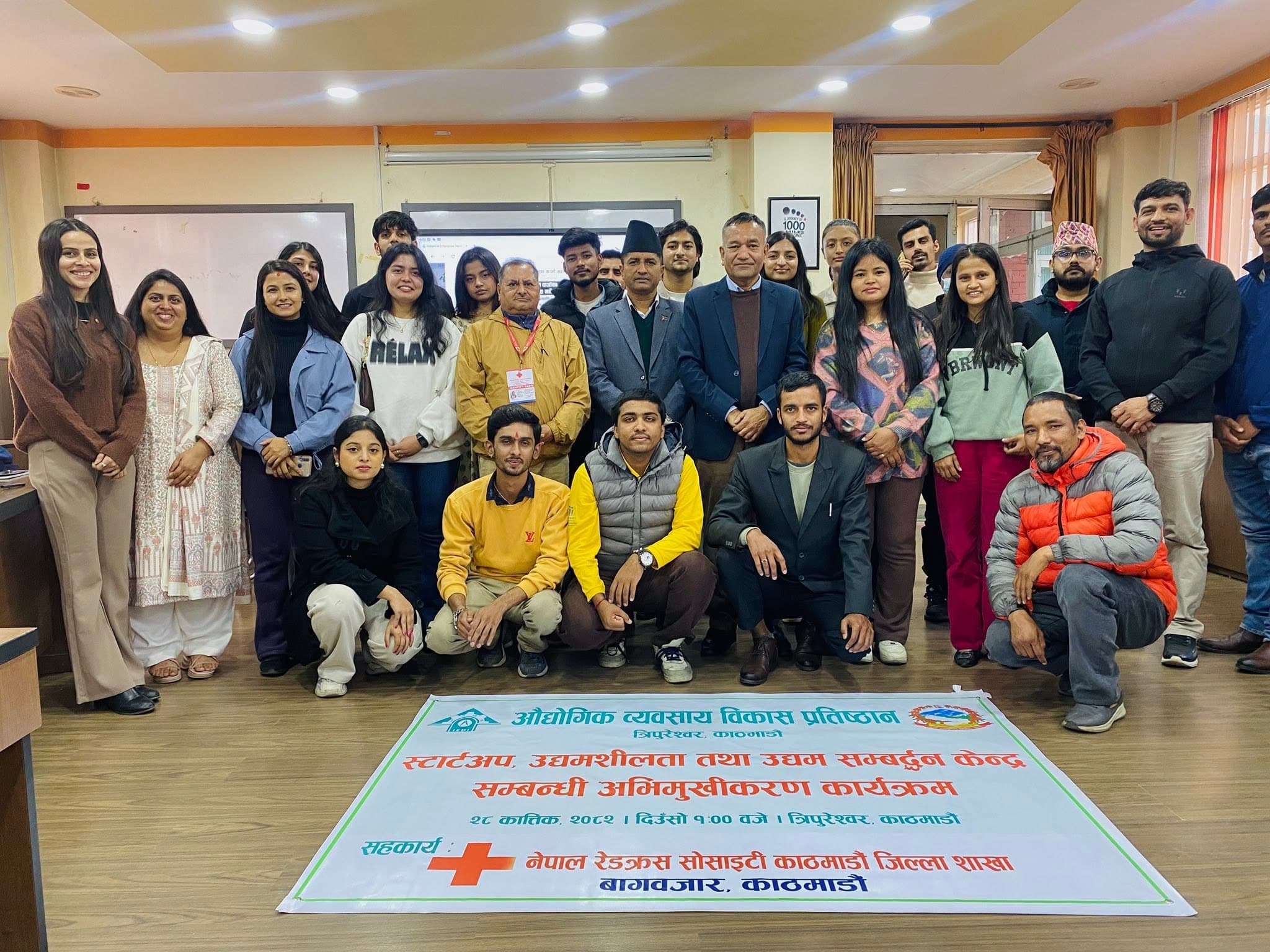 Group of people posing behind a banner for a startup and entrepreneurship orientation program.
